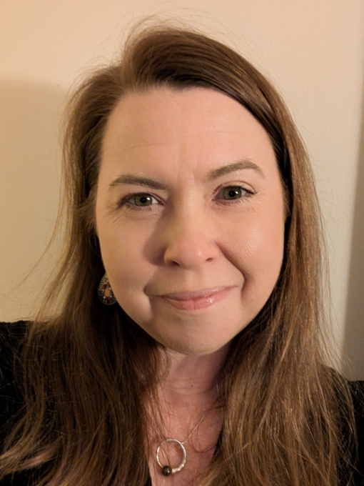 A profile photo of a woman in a black top with long blonde hair.