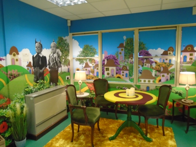 A creative corner of Race Leys Junior School's library with vibrant colourful walls and a table and chairs in the corner 