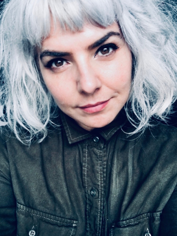 Woman with white short hair in a dark button up shirt